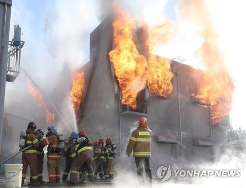 This undated file photo shows firefighters putting out an energy storage system fire. (Yonhap) 