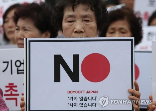 A protester holds up a banner bearing an appeal to boycott Japanese products during a rally against Japan held in central Seoul on July 30, 2019. (Yonhap)
