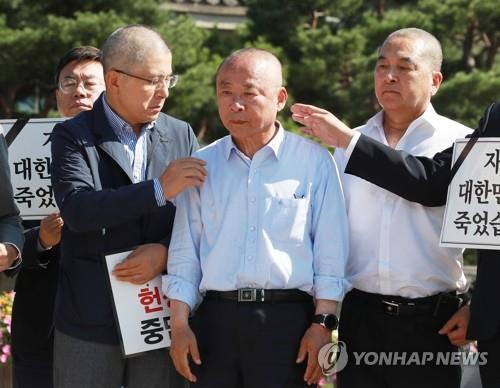 Rep. Lee Ju-young of the Liberty Korea Party (LKP) (C), deputy speaker of the National Assembly, and Rep. Shim Jae-chul (R) of the same party appear before reporters after shaving their heads in front of the presidential office Cheong Wa Dae in Seoul on Sept. 18, 2019, in protest of President Moon Jae-in's appointment of Cho Kuk as his new justice minister. To the left of Lee is LKP Chairman Hwang Kyo-ahn, who had his head shaved at the same place Monday. (Yonhap)
