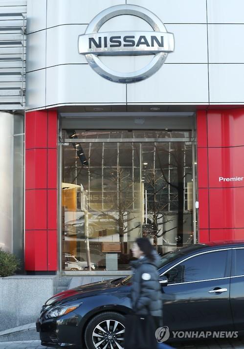 A woman walks past an outlet of the South Korean unit of Nissan Motor Co. in Seoul on Nov. 29, 2016. (Yonhap)