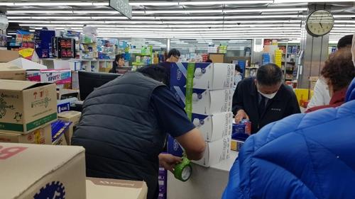 A worker packages boxes of facial masks at a pharmacy in Jongno, central Seoul, on Jan. 31, 2020, amid growing concerns about the spread of the new strain of coronavirus. (Yonhap)