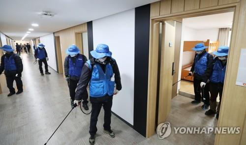 Workers at a youth hostel in Suwon, 46 kilometers south of Seoul, disinfect a room on Feb. 17, 2020, that will be used as a temporary self-quarantine facility by people suspected of having contracted the novel coronavirus. (Yonhap) 