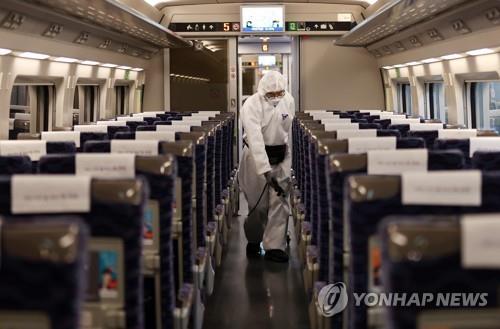 Petugas menyemprotkan disinfektan di kabin Kereta KTX di Stasiun Suseo, Seoul