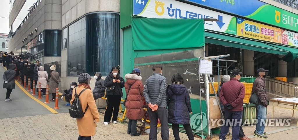 People wait in line to buy masks in front of a local supermarket in the southeastern city of Daegu on March 7, 2020. (Yonhap)