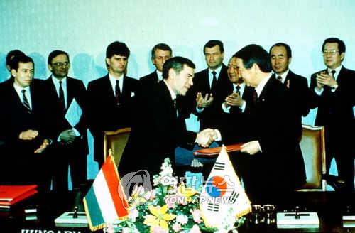 This file photo, taken Feb. 10, 1989, shows then South Korean Foreign Minister Choi Ho-joong (R) shaking hands with his Hungarian counterpart, Gyula Horn, after establishing the two countries' diplomatic relations. (Yonhap) 