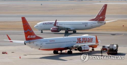 This file photo taken Dec. 19, 2019, shows planes operated by Jeju Air and Eastar Jet at Gimpo International Airport in western Seoul. (Yonhap)