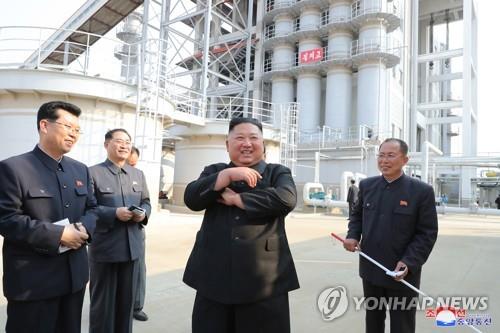 North Korean leader Kim Jong-un (C) smiles while joining a fertilizer factory completion ceremony in this photo released by the KCNA on May 2, 2020. This marked his first public appearance after 20 days of absence that sparked rumors about his health. (For Use Only in the Republic of Korea. No Redistribution) (Yonhap)