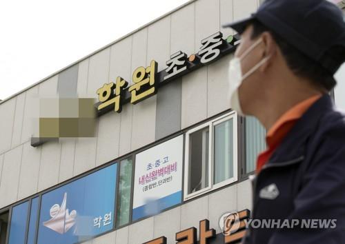 This file photo taken on May 14, 2020, shows a masked citizen passing by a private academy in Incheon, where a coronavirus-infected instructor taught students. (Yonhap)