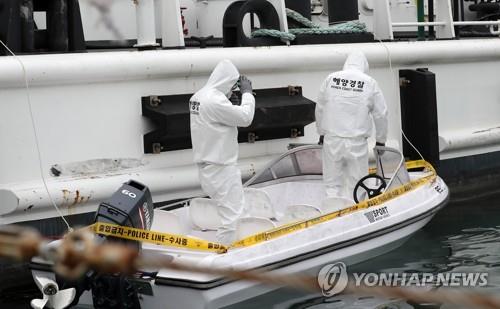 Coast Guard officers investigate a 1.5-ton boat in the western coastal town of Taean, South Chungcheong Province, on May 15, 2020, a day after the boat was found abandoned. (Yonhap)