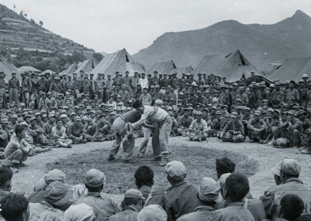A crowd of POWs gather to see a traditional Korean wrestling match at the Geoje camp in a photo taken by the ICRC in June 1951. (PHOTO NOT FOR SALE) (Yonhap)