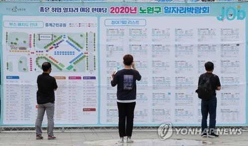 The file photo taken July 15, 2020, shows jobseekers looking at the floor plan of a recruitment event in Seoul. (Yonhap)
