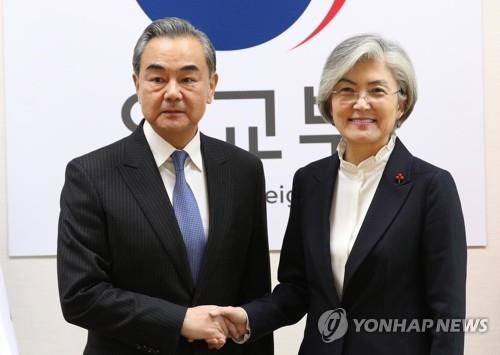 This photo, taken on Dec. 4, 2019, shows Foreign Minister Kang Kyung-wha (R) shaking hands with her Chinese counterpart, Wang Yi, before their talks at the foreign ministry in Seoul. (Yonhap)