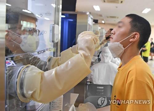 A military official collects a sample from an enlistee for a coronavirus test upon his joining the military at a Navy boot camp on July 20, 2020, in this photo provided by the Navy. (PHOTO NOT FOR SALE) (Yonhap)