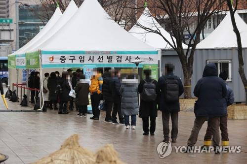 People wait in a line for coronavirus tests at a makeshift clinic at the plaza in front of Seoul City Hall on Jan. 15, 2021. (Yonhap)
