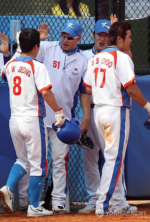 In this file photo from Nov. 18, 2010, Jeong Keun-woo (L) and Choo Shin-soo of South Korea are greeted by their teammates after scoring on Kim Tae-kyun's double against China in the bottom of the fifth inning of the semifinal in the baseball tournament at the Guangzhou Asian Games at Aoti Baseball Field in Guangzhou, China. (Yonhap)