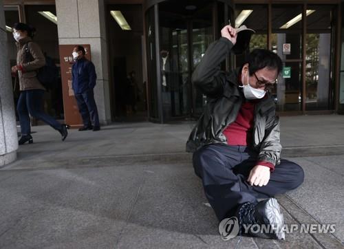 A former inmate of Brothers Home slumps on the floor outside the Supreme Court in Seoul and cries upon the dismissal of an appeal filed against a not-guilty verdict for Park In-keun, the owner of Brothers Home, the state-run facility for vagrants, on March 11, 2021. (Yonhap) 