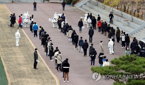The undated file photo shows students line up to receive coronavirus testing. (Yonhap)