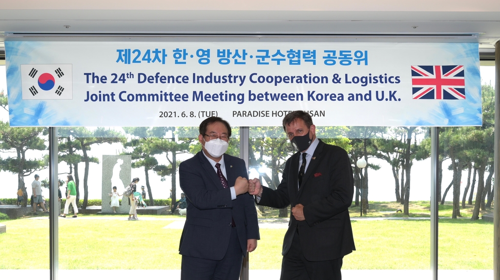 Seo Hyeung-jin (L), the vice chief of the Defense Acquisition Program Administration, and Mark Goldsack, the director of Britain's Department for International Trade Defence and Security Organisation pose for a photo during a meeting in the southeastern city of Busan on June 8, 2021, in the photo provided by the arms procurement agency. (PHOTO NOT FOR SALE) (Yonhap) 