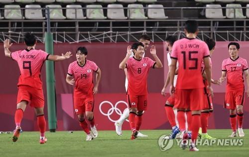 Lee Kang-in (C), a midfielder of South Korea's men's football squad, celebrates with his teammates after scoring the team's fourth goal during a Group B match against Romania at the Tokyo Olympics on July 25, 2021, in Kashima, some 110 kilometers northeast of Tokyo. South Korea won the match 4-0. (Yonhap)
