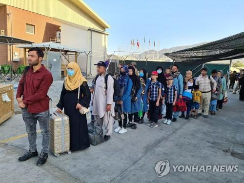 Afghans wait to board a South Korean military plane at an airport in Kabul, in this photo provided by the Ministry of Foreign Affairs on Aug. 25, 2021. (PHOTO NOT FOR SALE) (Yonhap) 