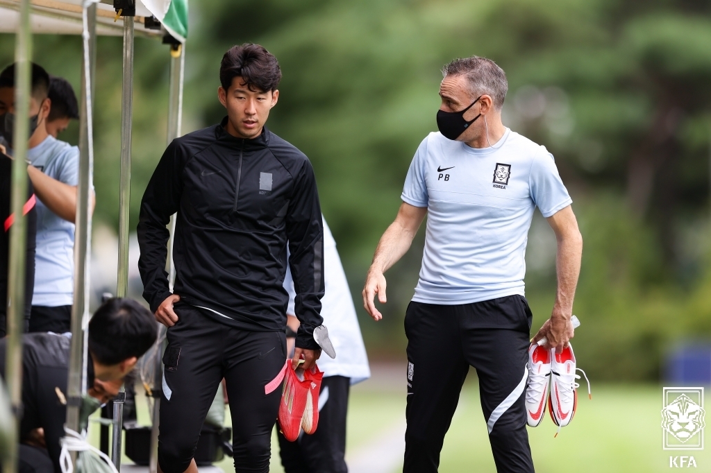 Paulo Bento (R), head coach of the South Korean men's national football team, speaks with captain Son Heung-min during practice at the National Football Center in Paju, Gyeonggi Province, on Sept. 1, 2021, ahead of a World Cup qualifier against Iraq, in this photo provided by the Korea Football Association. (PHOTO NOT FOR SALE) (Yonhap)