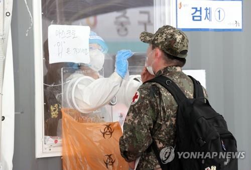 This file photo, taken on May 24, 2021, shows a soldier receiving a COVID-19 test at a makeshift virus testing site in central Seoul. (Yonhap)