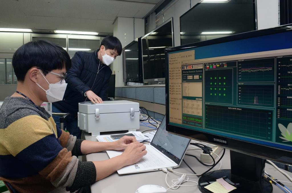 This undated photo, provided by the Electronics and Telecommunications Research Institute (ETRI) on Jan. 6, 2022, shows researchers conducting a check of the newly developed 5G-satellite multiple network system. (PHOTO NOT FOR SALE) (Yonhap)