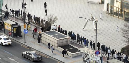 People line up in front of a sales outlet in Seoul to buy lottery tickets on Jan. 2, 2022. (Yonhap)
