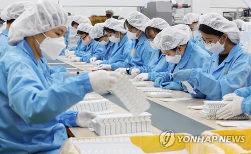 Workers at a plant manufacture COVID-19 rapid antigen test kits in Chungju, 147 kilometers south of Seoul, on Feb. 11, 2021. (Yonhap) 