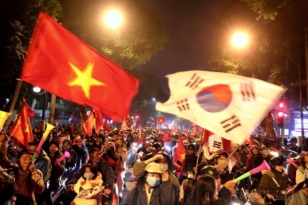 This file photo provided by Vietnam News Agency shows thousands of football fans pouring into the streets in Hanoi on the evening of Dec. 10, 2019, carrying national flags of Vietnam and South Korea to celebrate the first-ever Southeast Asian Games victory by Vietnam's U22 squad. (PHOTO NOT FOR SALE) (Yonhap)