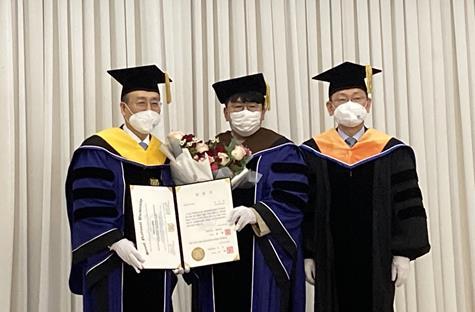 Bang Si-hyuk (C), founder and chairman of K-pop powerhouse Hybe that manages BTS, receives an honorary doctorate on business administration from Seoul National University in southern Seoul on April 28, 2022. (Yonhap)