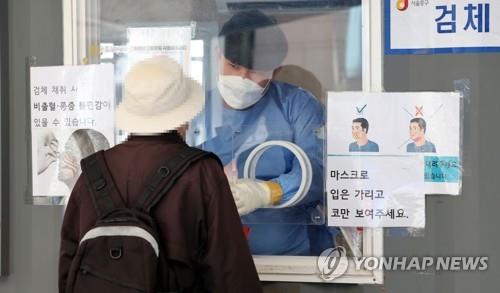 A person takes a COVID-19 test at a provisional testing center near Seoul Station in Seoul on May 5, 2022. (Yonhap)