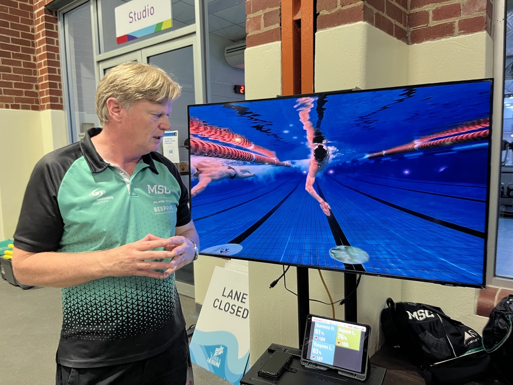 Australian swimming coach Ian Pope studies the video of South Korean swimmer Hwang Sun-woo during a training session in Melbourne, in this photo provided by the Korea Swimming Federation on May 10, 2022. (PHOTO NOT FOR SALE) (Yonhap)