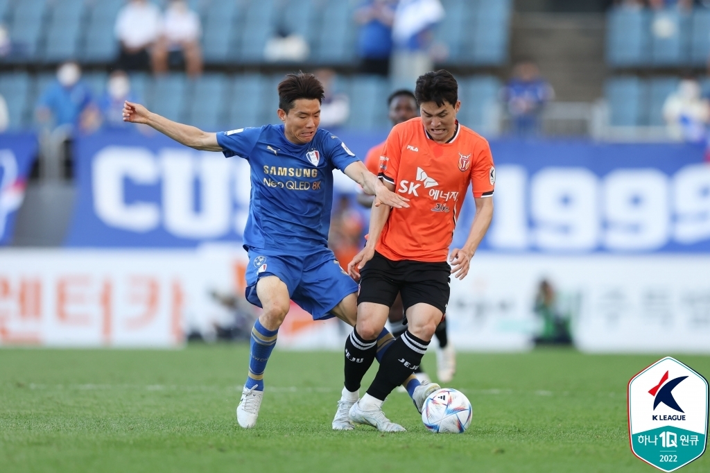 Ryu Seung-woo of Suwon Samsung Bluewings (L) and Jo Seong-joon of Jeju United battle for the ball during their clubs' K League 1 match at Jeju World Cup Stadium in Seogwipo, Jeju Island, on May 22, 2022, in this photo provided by the Korea Professional Football League. (PHOTO NOT FOR SALE) (Yonhap)