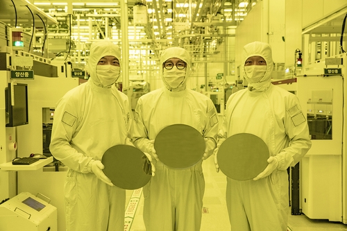 Samsung Electronics executives hold 3-nanometer semiconductor wafers in this photo provided by Samsung Electronics Co. on June 30, 2022. (Yonhap) 