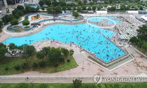 Giant swimming facilities at a public park in Ddukseom, eastern Seoul, bustle with visitors, in this June 26, 2022, file photo. (Yonhap)