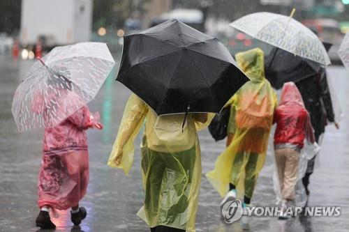 Children walk in raincoats holding umbrellas in central Seoul on Sept. 5, 2022. (Yonhap)