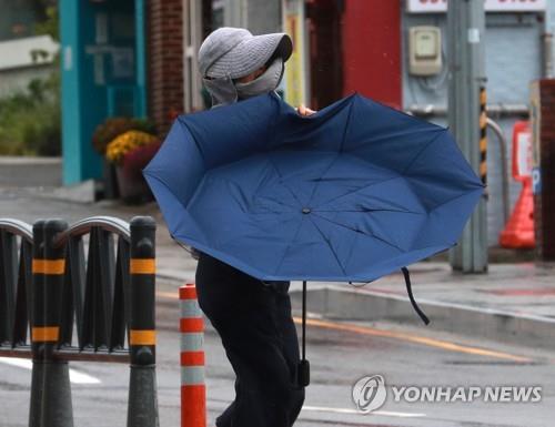 A person walks on a seaside street in Busan, 325 kilometers southeast of Seoul, on Sept. 19, 2022, as Typhoon Nanmadol brushes past South Korea. (Yonhap)