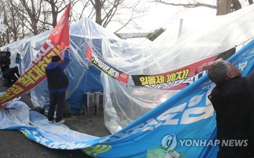 Cargo truckers demolish protest tents in front of a post office in Daejeon on Dec. 9, 2022, after their union voted to end their weekslong strike. (Yonhap)