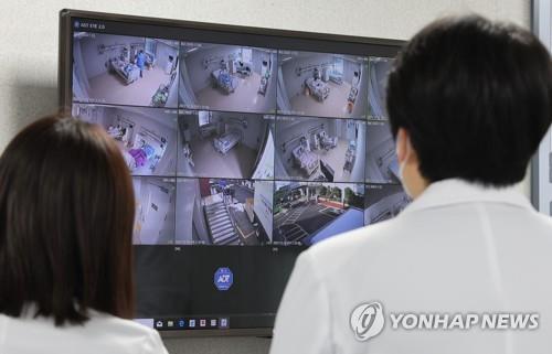 Medical personnel watch a screen monitoring the negative pressure treatment ward at the National Medical Center in central Seoul on Dec. 20, 2022. 