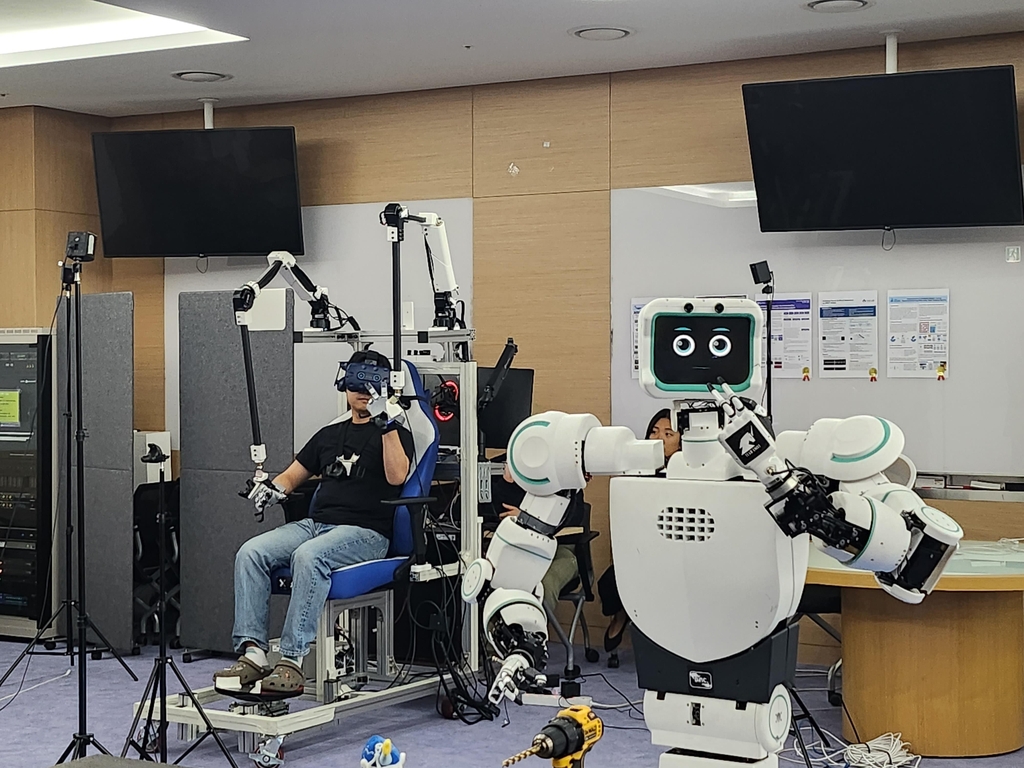 Avatar (R), a robot developed by professor Bae Joon-bum and his team, and its operator (L) pose for the camera in a lab at the Ulsan National Institute of Science and Technology on April 28, 2023. (Yonhap)