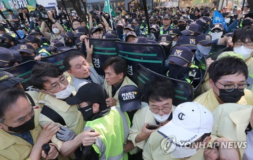Oficiales de policía y funcionarios del gobierno local participan en un enfrentamiento físico horas antes del 15º Festival de Cultura Queer de Daegu en la ciudad de Daegu, en el sureste del país, el 17 de junio de 2023. (Yonhap)