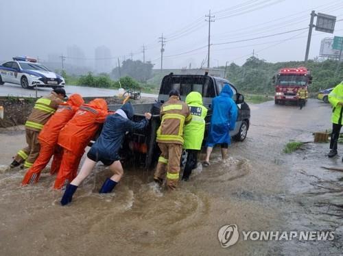 Los bomberos sacan un camión de un área sumergida en la ciudad portuaria de Busan, en el sureste del país, en esta foto proporcionada por las autoridades de bomberos el 16 de julio de 2023. (FOTO NO A LA VENTA) (Yonhap)