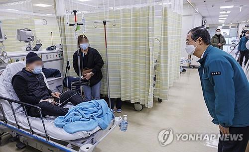El primer ministro Han Duck-soo (derecha) se reúne con un paciente en un centro médico público en Seúl el 1 de marzo de 2024. (Yonhap)