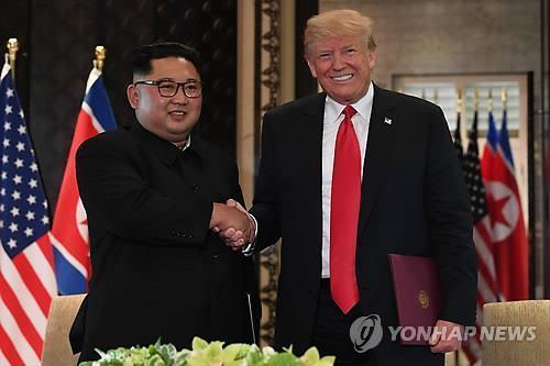 Esta fotografía de la AFP muestra al entonces presidente de Estados Unidos, Donald Trump (derecha), estrechando la mano del líder norcoreano Kim Jong-un después de firmar una declaración conjunta en el Hotel Capella en la isla Sentosa en Singapur el 12 de junio de 2018. (Yonhap)