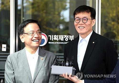 Finance Minister Choi Sang-mok (L) and Bank of Korea Gov. Rhee Chang-yong smile as Rhee visits the finance ministry in the central city of Sejong on Sept. 30, 2024, for a meeting on structural reform. (Yonhap)