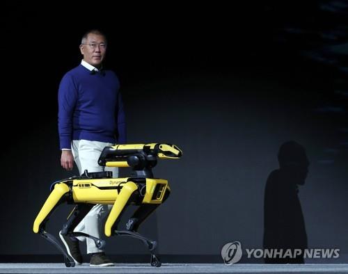 Esta foto de archivo muestra al presidente de Hyundai Motor Group, Chung Eui-sun, subiendo al escenario con Spot, un robot de cuatro patas, durante una conferencia de prensa en Las Vegas el 4 de enero de 2022. (Yonhap)