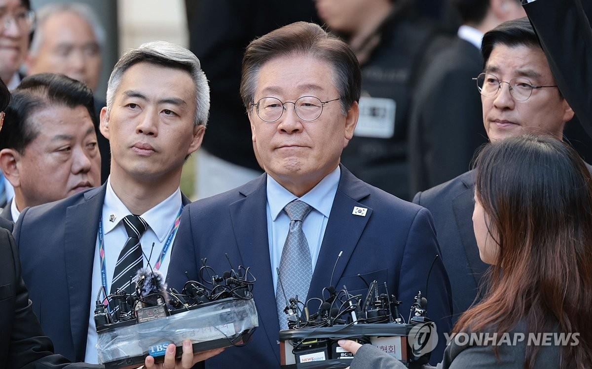 El líder de la oposición, Lee Jae-myung (centro), responde a las preguntas de los periodistas frente al Tribunal del Distrito Central de Seúl, en el sur de Seúl, el 15 de noviembre de 2024, después de que el tribunal lo condenara a una pena de prisión suspendida de un año por mentir durante la campaña electoral presidencial de 2022. . (Yonhap)