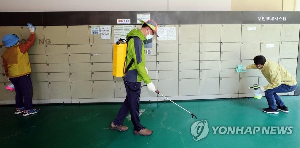 Des officiels de quarantaine désinfectent des boîtes à colis dans un appartement à Gwangju, à 330 km au sud de Séoul, le jeudi 28 mai 2020.