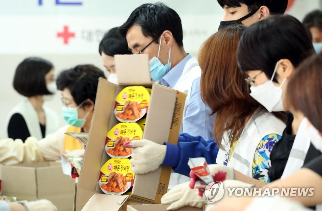 Des bénévoles préparent des paquets alimentaires pour des ménages défavorisées sur fond de pandémie de nouveau coronavirus (Covid-19) dans un bureau de la Croix-Rouge sud-coréenne à Séoul, le mercredi 3 juin 2020.